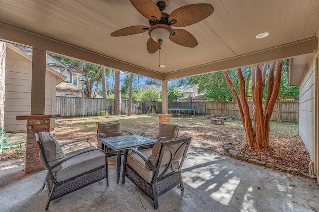 view of patio / terrace featuring ceiling fan, outdoor dining area, a trampoline, and a fenced backyard