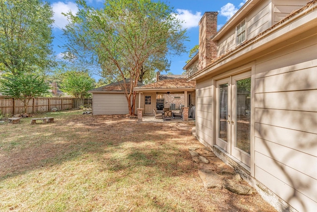 view of yard featuring a patio, french doors, fence, and a ceiling fan