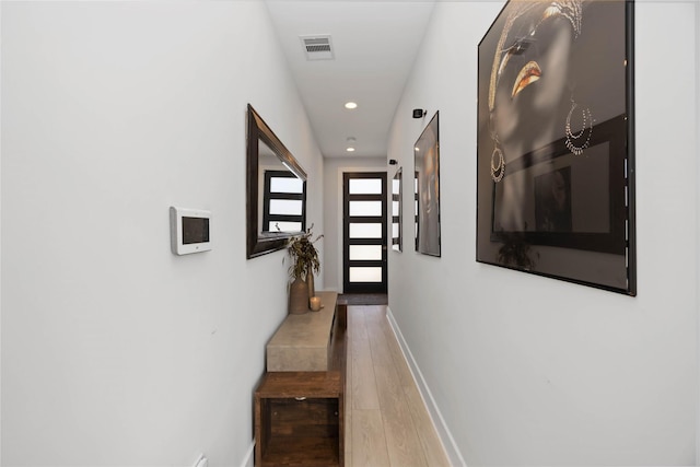 hallway featuring recessed lighting, visible vents, baseboards, and wood finished floors