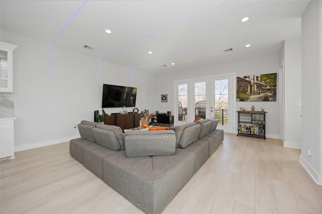 living room with recessed lighting, visible vents, baseboards, light wood-style floors, and french doors