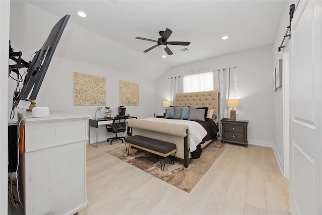 bedroom with light wood finished floors, a barn door, visible vents, vaulted ceiling, and recessed lighting