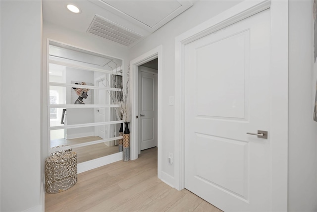 corridor with light wood finished floors, attic access, visible vents, baseboards, and recessed lighting