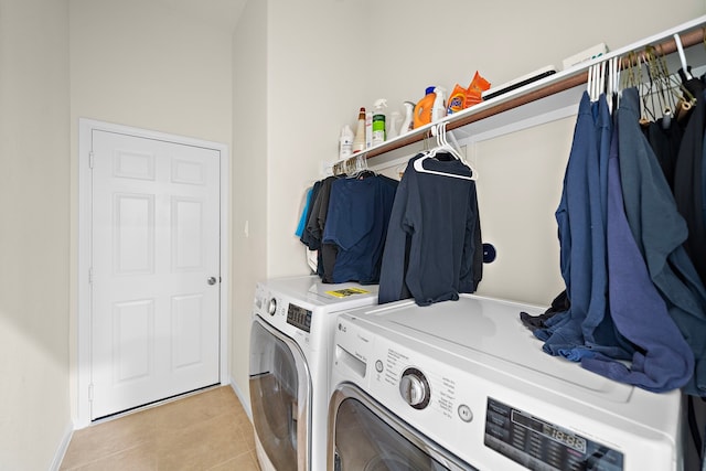 laundry area with laundry area, washer and clothes dryer, baseboards, and light tile patterned floors