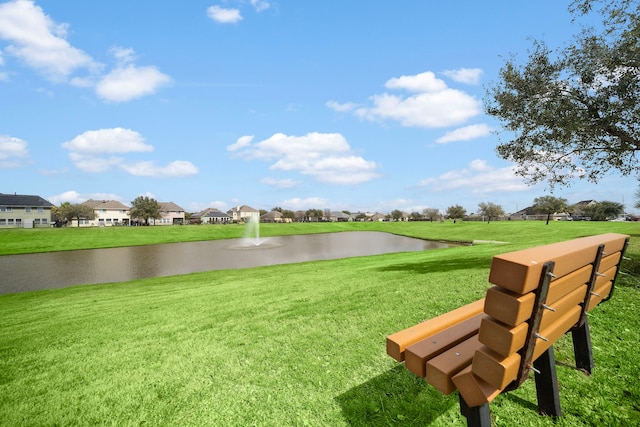 view of property's community with a water view and a yard