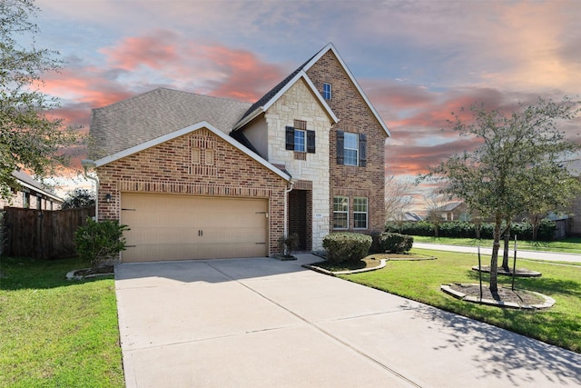 traditional-style home featuring brick siding, a shingled roof, a garage, driveway, and a front lawn