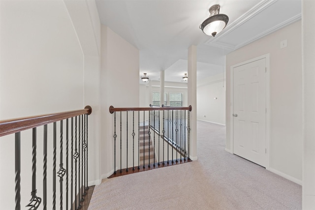 hall featuring carpet, attic access, baseboards, and an upstairs landing