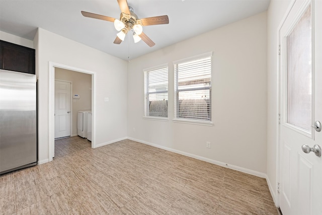 unfurnished room featuring a ceiling fan, washer and dryer, and baseboards