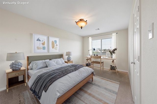 bedroom with baseboards, visible vents, and light colored carpet