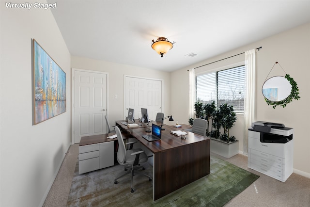 carpeted office space with visible vents and baseboards