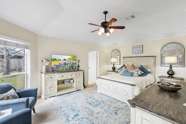 bedroom featuring vaulted ceiling, a ceiling fan, visible vents, and light colored carpet