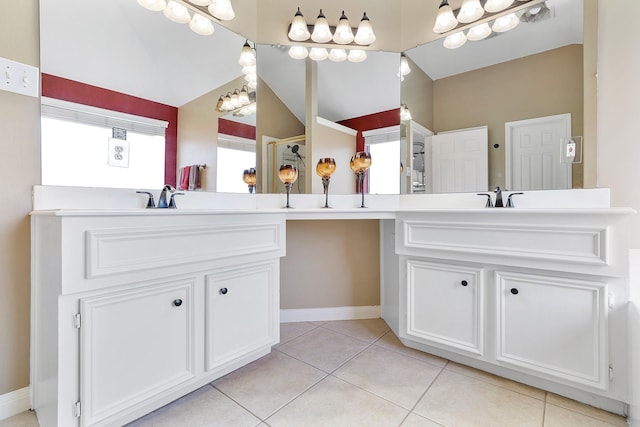 bathroom featuring vaulted ceiling, baseboards, vanity, and tile patterned floors