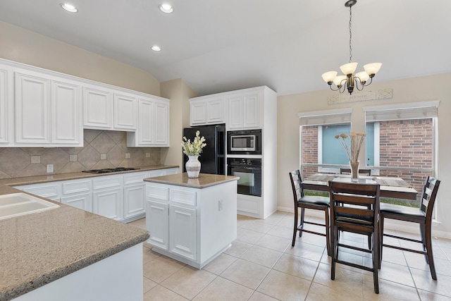 kitchen with lofted ceiling, backsplash, white cabinetry, a chandelier, and black appliances