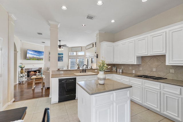 kitchen with black dishwasher, decorative columns, visible vents, and a sink