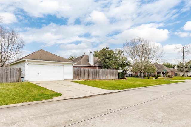 view of side of home with a garage, driveway, fence, and a yard