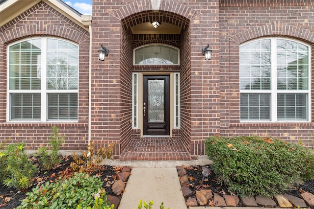 view of exterior entry with brick siding