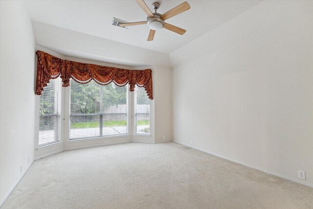 carpeted empty room featuring a ceiling fan, visible vents, and baseboards