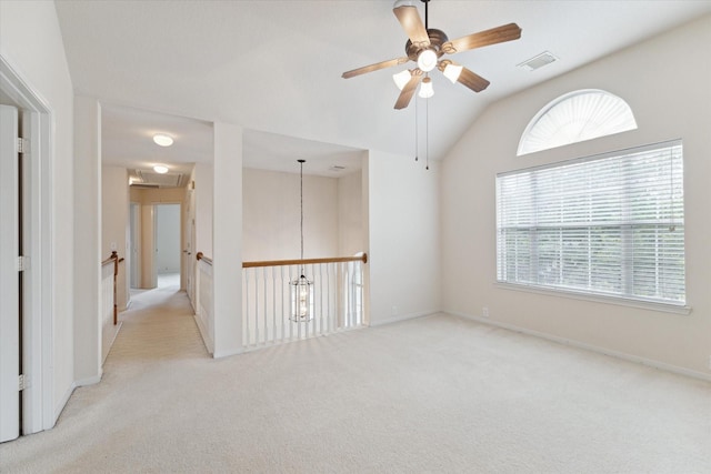 empty room featuring carpet, lofted ceiling, visible vents, a ceiling fan, and baseboards