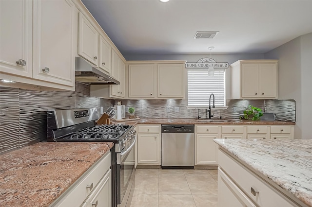 kitchen with stainless steel appliances, visible vents, light tile patterned flooring, a sink, and under cabinet range hood