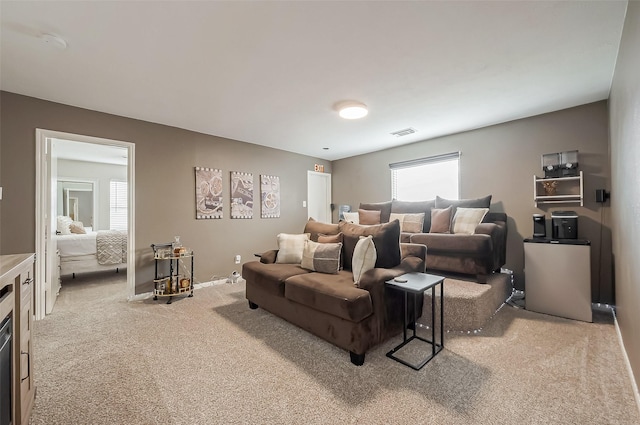 living area featuring carpet floors, baseboards, and visible vents