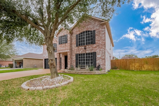 traditional-style home featuring concrete driveway, brick siding, a front lawn, and fence