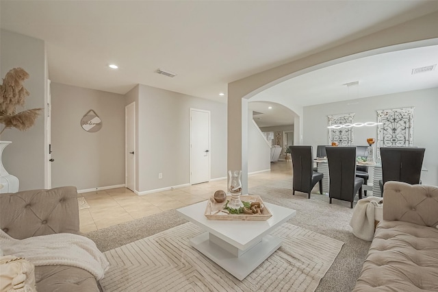 living area featuring arched walkways, visible vents, recessed lighting, and light tile patterned floors