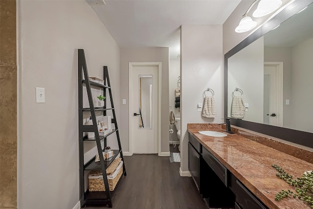 bathroom featuring toilet, wood finished floors, visible vents, vanity, and baseboards