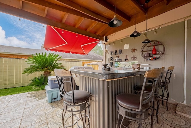 bar featuring indoor wet bar and beamed ceiling