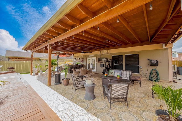 view of patio featuring french doors, outdoor dining area, outdoor lounge area, and fence