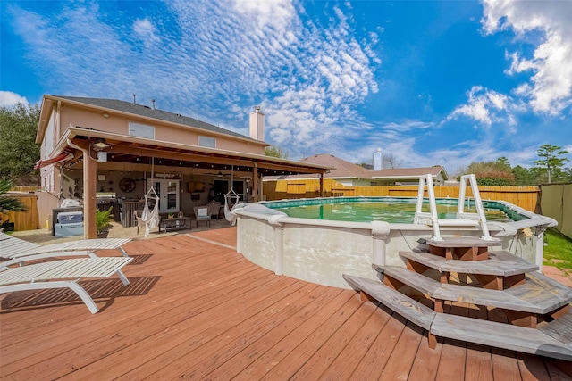 wooden deck featuring fence and a fenced in pool