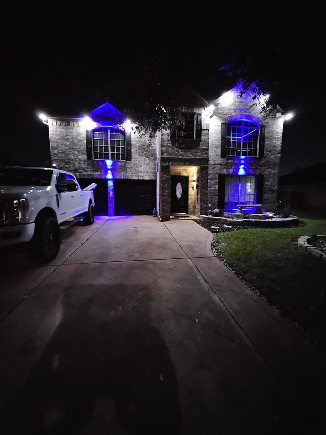 traditional home with a garage, stone siding, and driveway