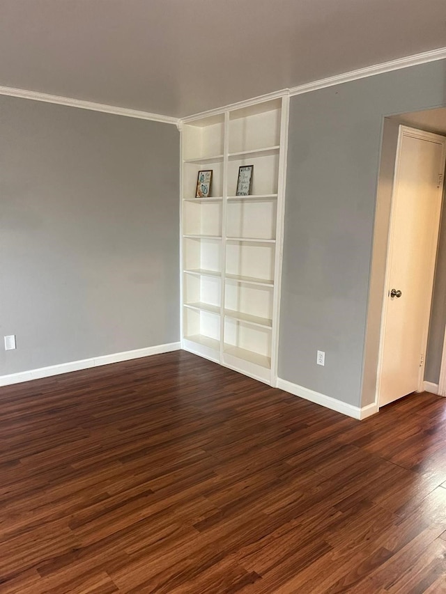 unfurnished room with dark wood-style floors, built in features, and baseboards