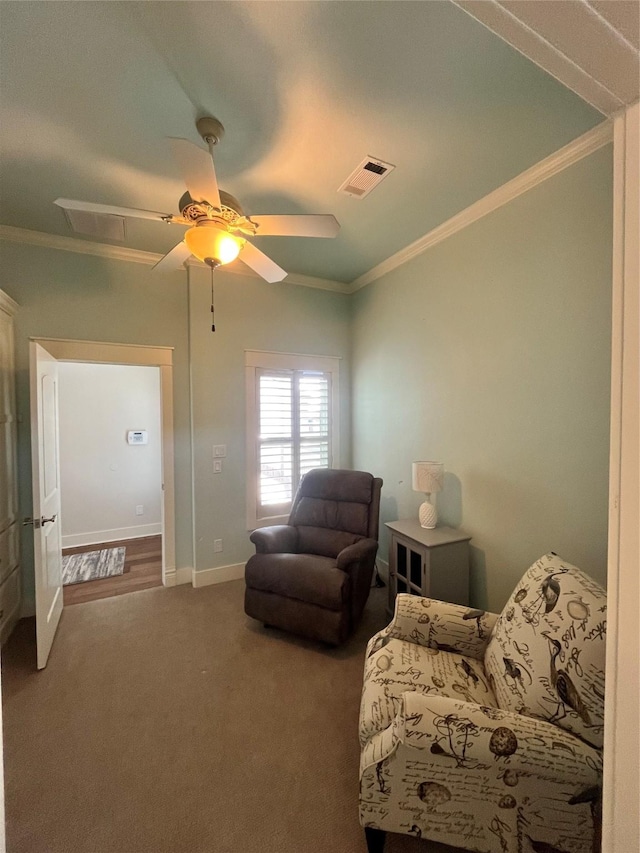 living area with ornamental molding, carpet flooring, visible vents, and baseboards