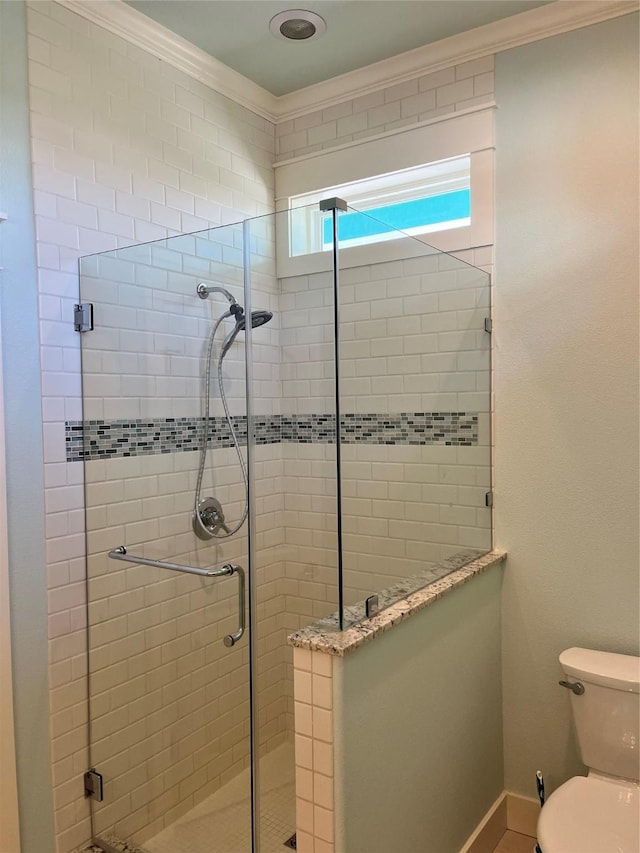 full bath featuring toilet, a shower stall, baseboards, and crown molding