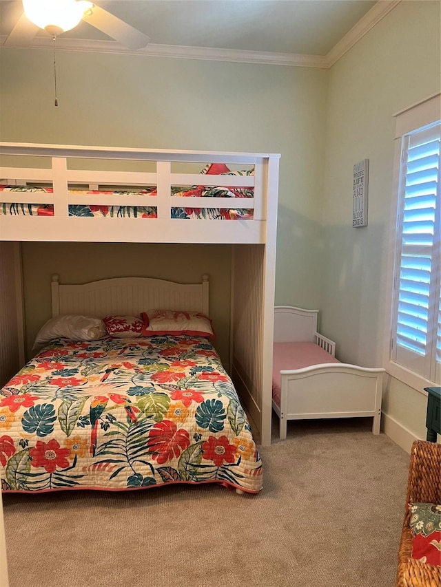 bedroom featuring ceiling fan, ornamental molding, and carpet flooring