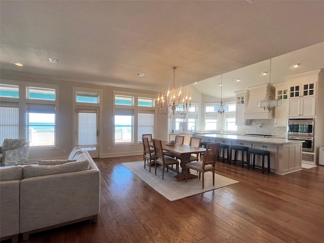 dining area featuring visible vents, an inviting chandelier, dark wood-type flooring, ornamental molding, and baseboards