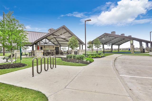 view of community with uncovered parking, a lawn, and a gazebo