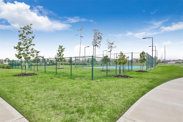 view of community featuring a yard and fence