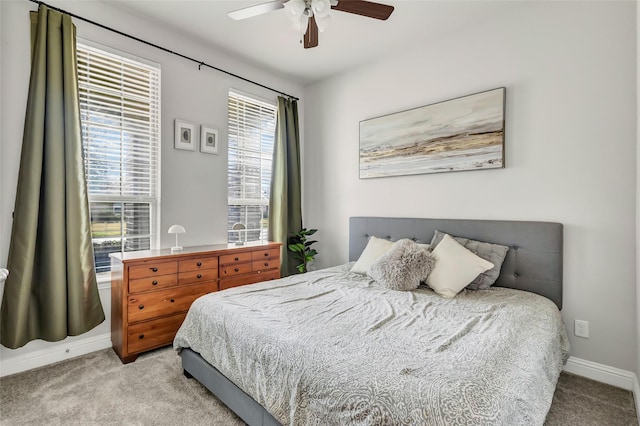 carpeted bedroom featuring baseboards and a ceiling fan