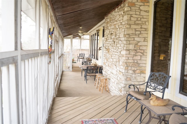 wooden deck featuring covered porch and a ceiling fan