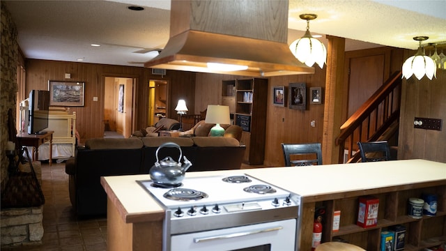 kitchen featuring visible vents, wood walls, tile patterned flooring, and white range with electric stovetop