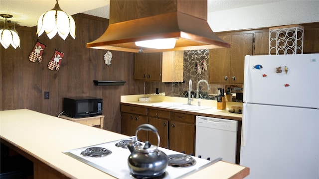 kitchen featuring white appliances, light countertops, island exhaust hood, and a sink