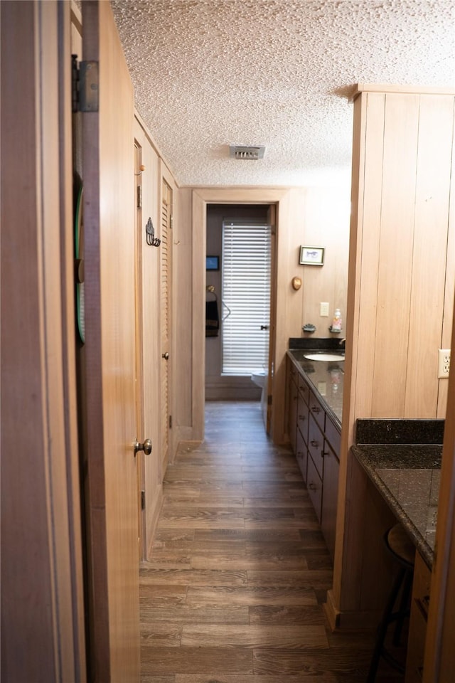 bathroom featuring visible vents, a textured ceiling, vanity, and wood finished floors