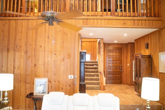 living room featuring recessed lighting, wood walls, stairway, and ceiling fan