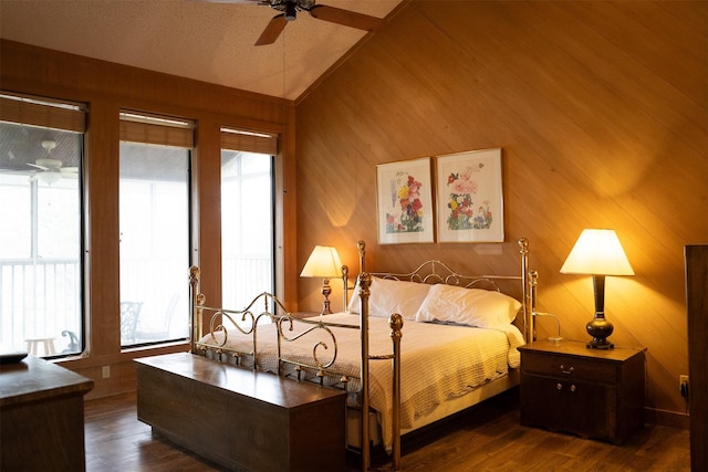 bedroom with lofted ceiling, ceiling fan, wood walls, and wood finished floors