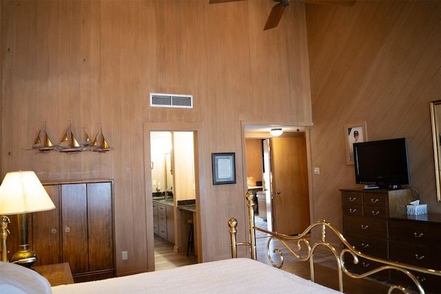 bedroom featuring visible vents, a high ceiling, and ensuite bathroom