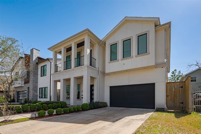 view of front of property featuring an attached garage, fence, concrete driveway, and stucco siding