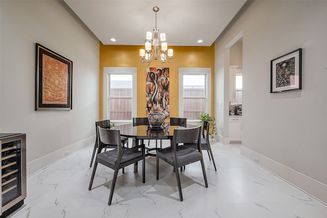 dining area featuring marble finish floor, recessed lighting, an inviting chandelier, beverage cooler, and baseboards