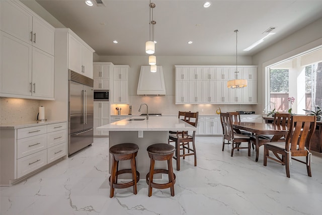 2217 W Main St, Houston, TX 77098 - kitchen featuring built in appliances, light marble finish floors, recessed lighting, decorative backsplash, and white cabinets
