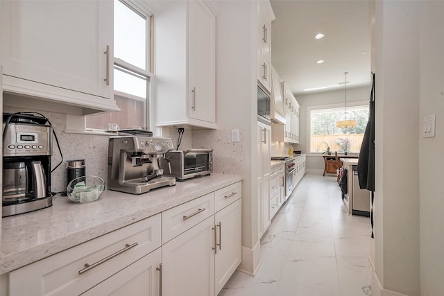 kitchen featuring a toaster, tasteful backsplash, appliances with stainless steel finishes, marble finish floor, and white cabinetry