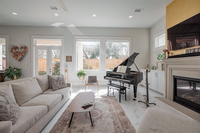 2217 W Main St, Houston, TX 77098 - living area with recessed lighting, french doors, a glass covered fireplace, and light marble finish flooring